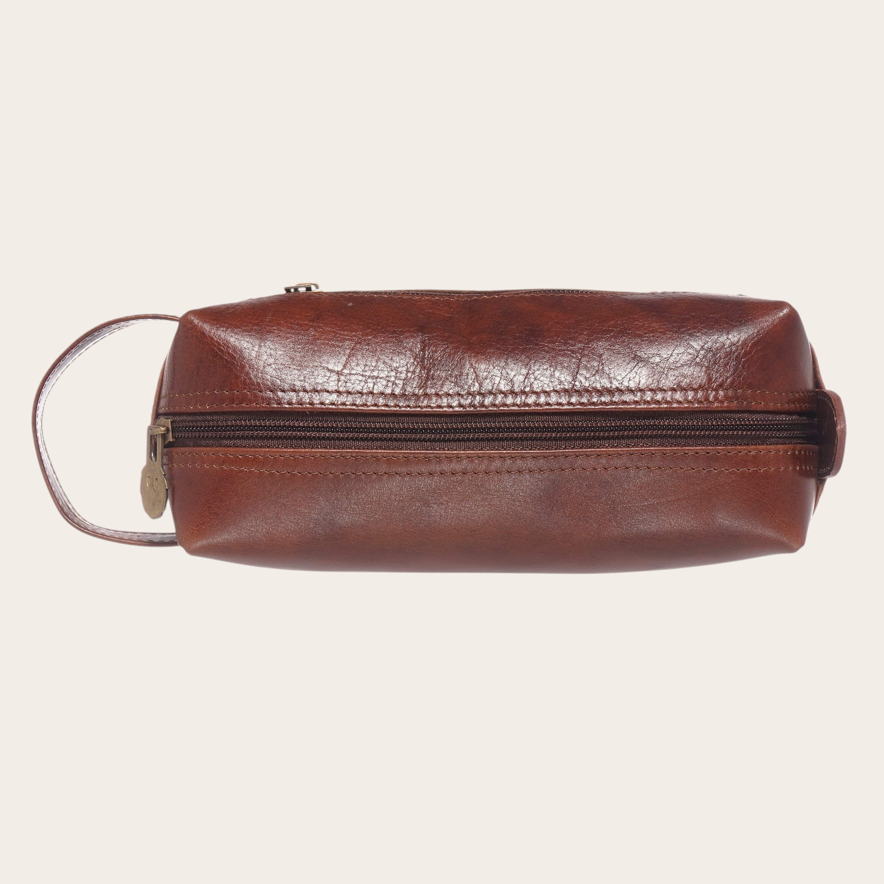 Neceser Elqui Castaño de OLKI en piel marrón, con cremallera y asa lateral. Ideal para viaje.