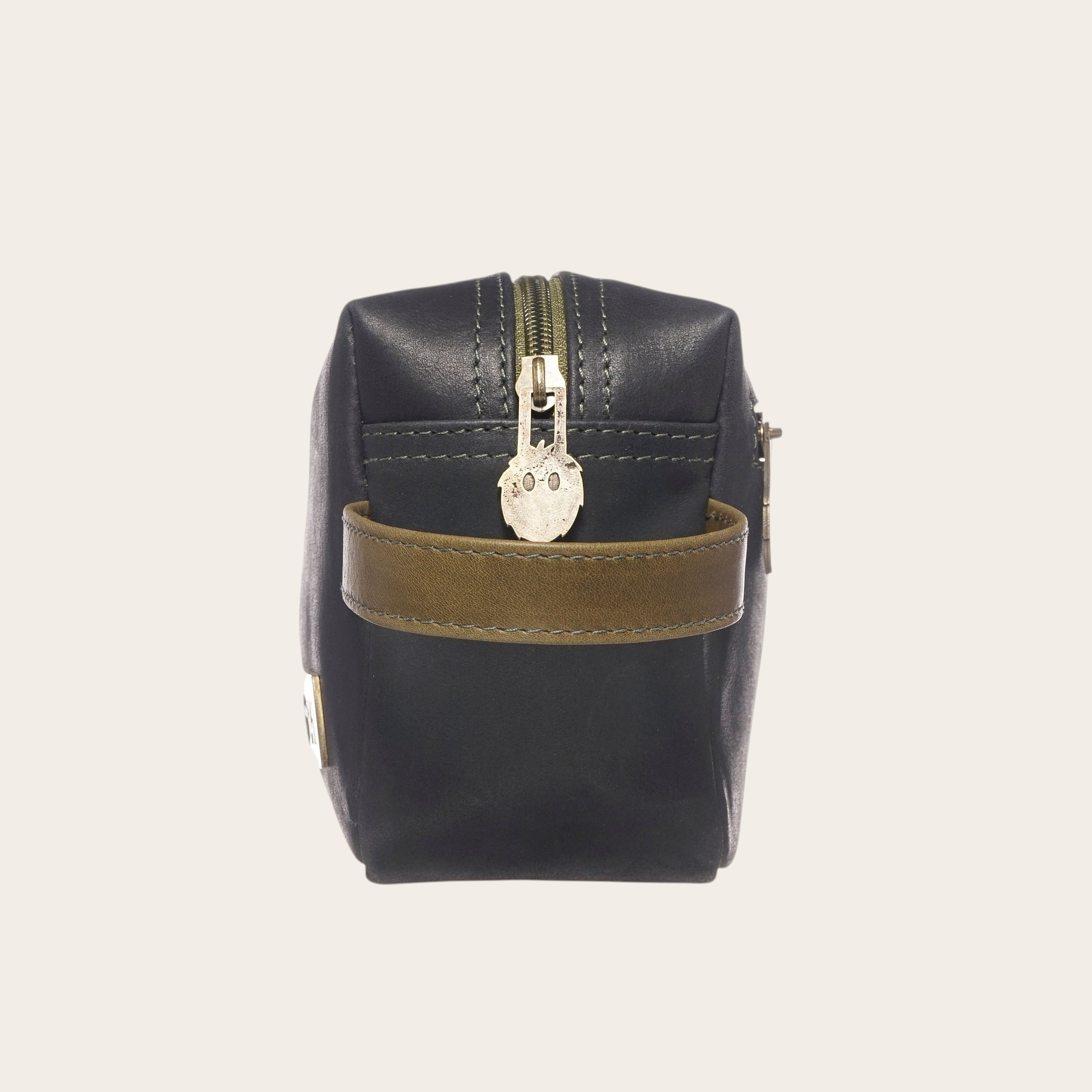 Neceser OLKI Elqui negro y verde con asa lateral de cuero y tirador de cremallera con diseño de cara.