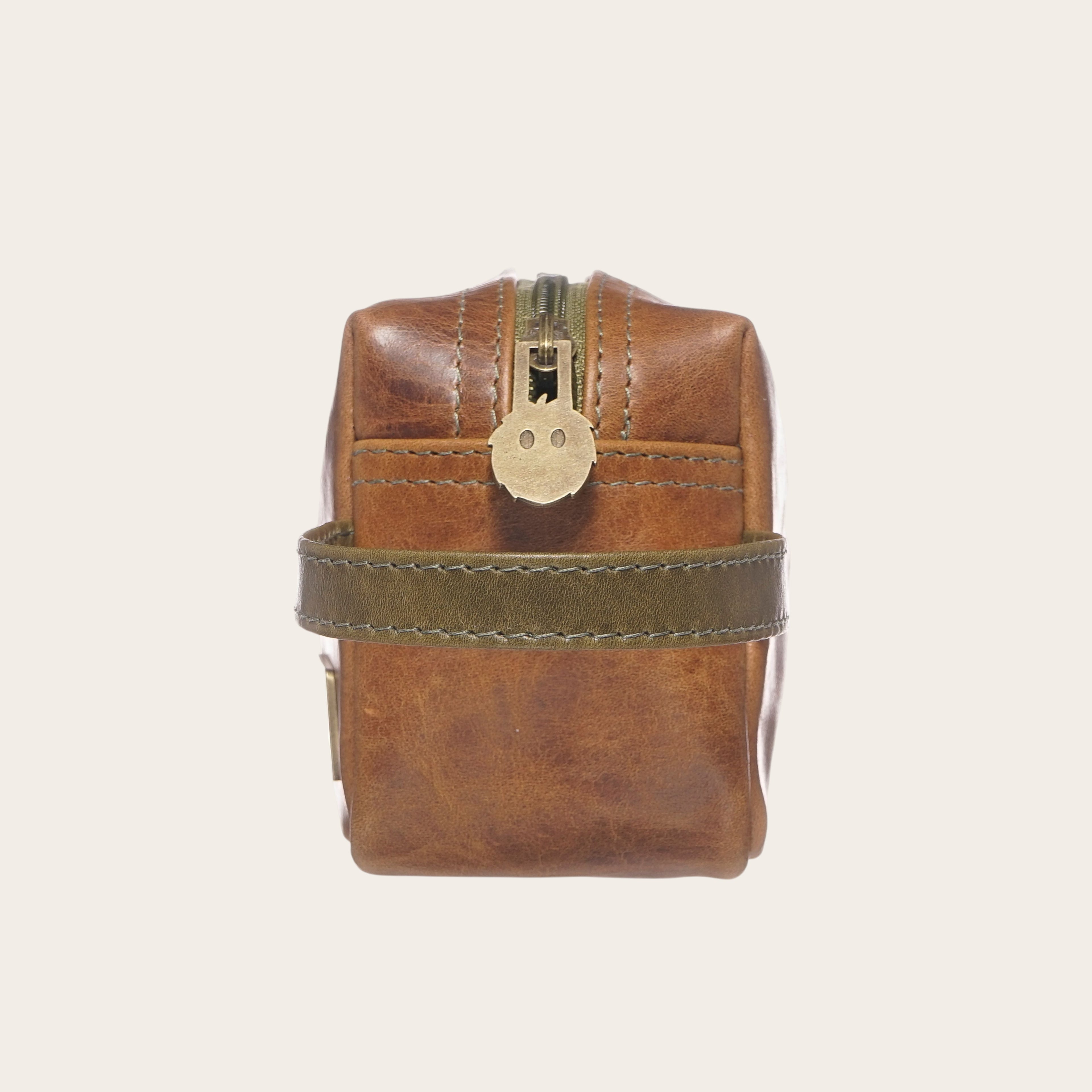 Neceser Lluta de cuero OLKI en caramelo y verde con cremallera. Ideal para organizar artículos de aseo.