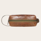 Neceser Lluta de cuero color caramelo de OLKI con cremallera verde y asa lateral. Ideal para organizar artículos de aseo.