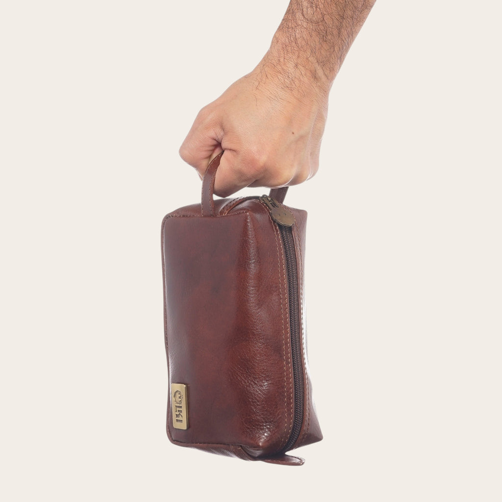 Neceser Lluta Castaño de cuero de OLKI, con cremallera y asa superior. Ideal para viajes.