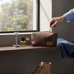 Neceser Lluta Chocolate de cuero marrón de OLKI con asa lateral y cierre de cremallera. Ideal para viajes.