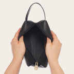 Neceser OLKI Lluta Negro de cuero con asa lateral y cremallera dorada. Diseño funcional y elegante.
