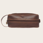 Neceser Loa Chocolate de cuero marrón de OLKI con asa lateral, ideal para viajes y organización.
