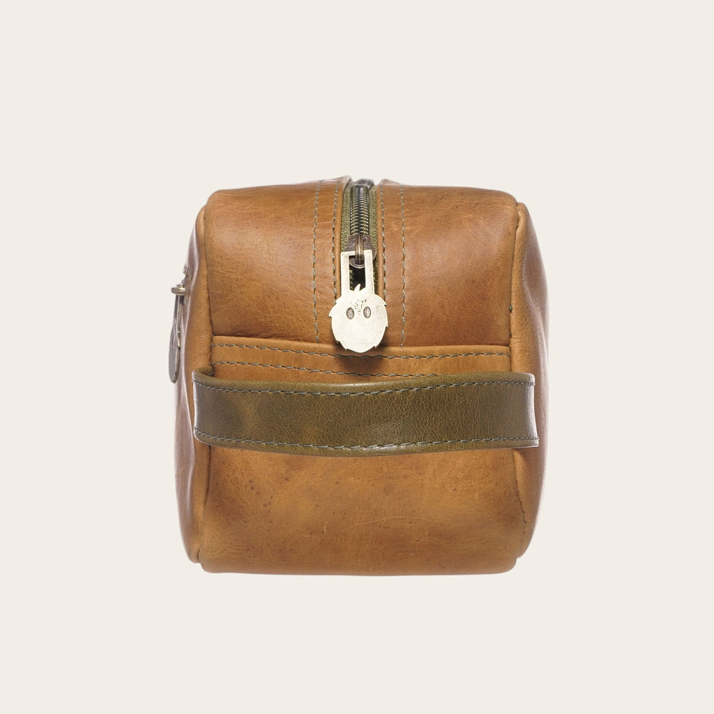 Neceser OLKI Loa de cuero color caramelo con cremallera verde y asa lateral. Ideal para viajes.