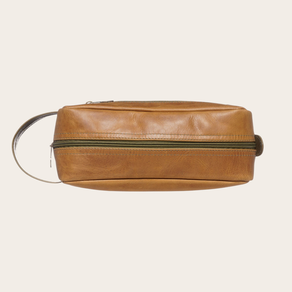 Neceser OLKI Loa de cuero color caramelo con cremallera verde y asa lateral. Ideal para viajes.