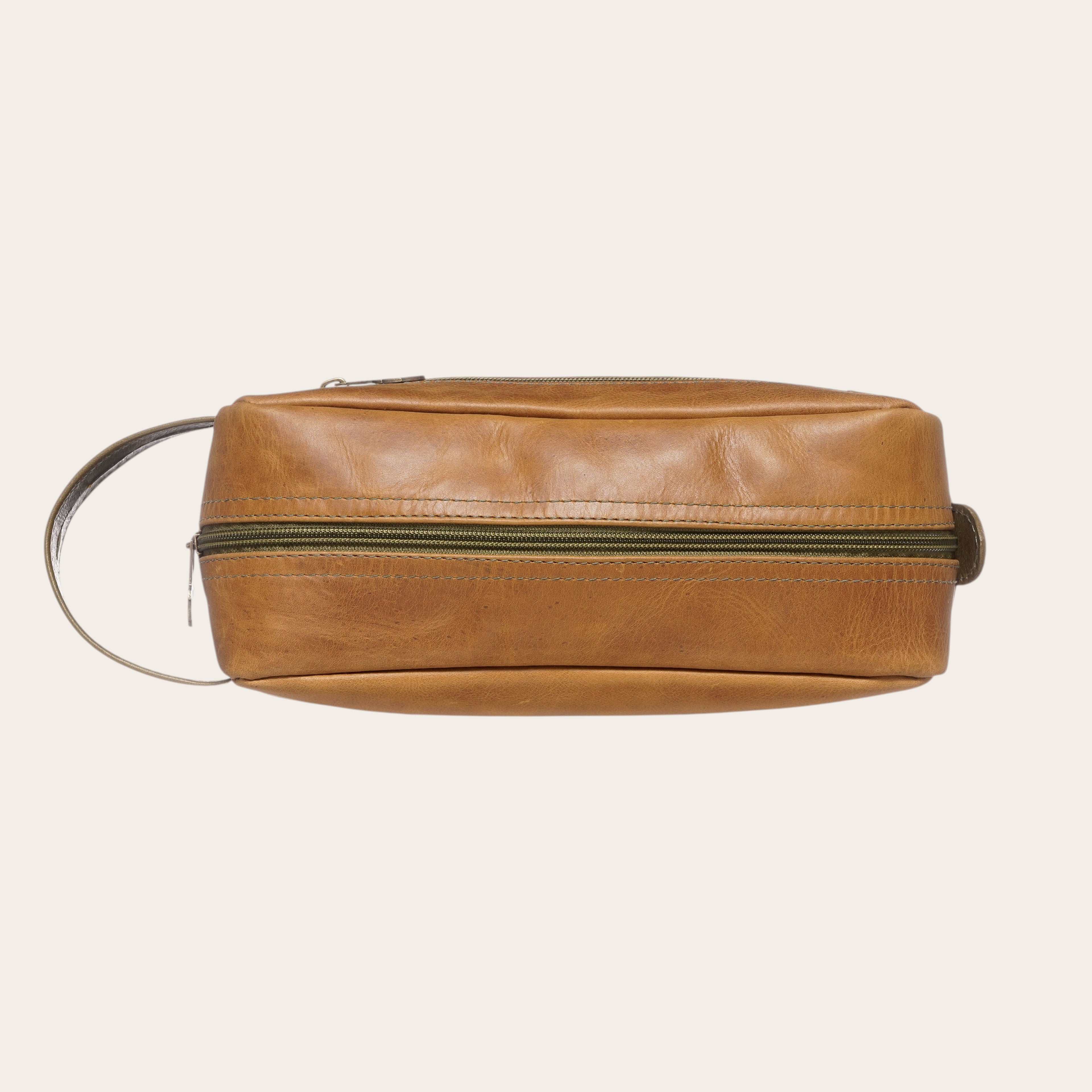 Neceser OLKI Loa de cuero color caramelo con cremallera verde y asa lateral. Ideal para viajes.