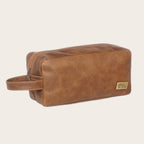 Neceser Loa Habano de OLKI en cuero natural marrón, con asa lateral y bolsillo exterior con cremallera. Ideal para viaje.
