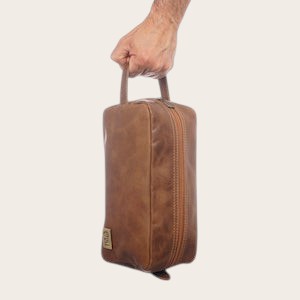 Neceser Loa Habano de cuero natural de OLKI con bolsillo exterior y asa lateral. Ideal para viaje y aseo.