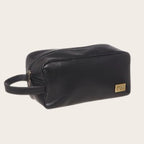 Neceser Loa Negro de cuero de OLKI con asa lateral y cierre de cremallera, ideal para organizar esenciales.
