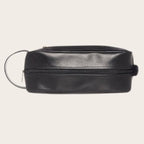 Neceser Loa Negro de cuero de OLKI con asa lateral y cierre de cremallera, ideal para organizar esenciales de viaje y aseo.