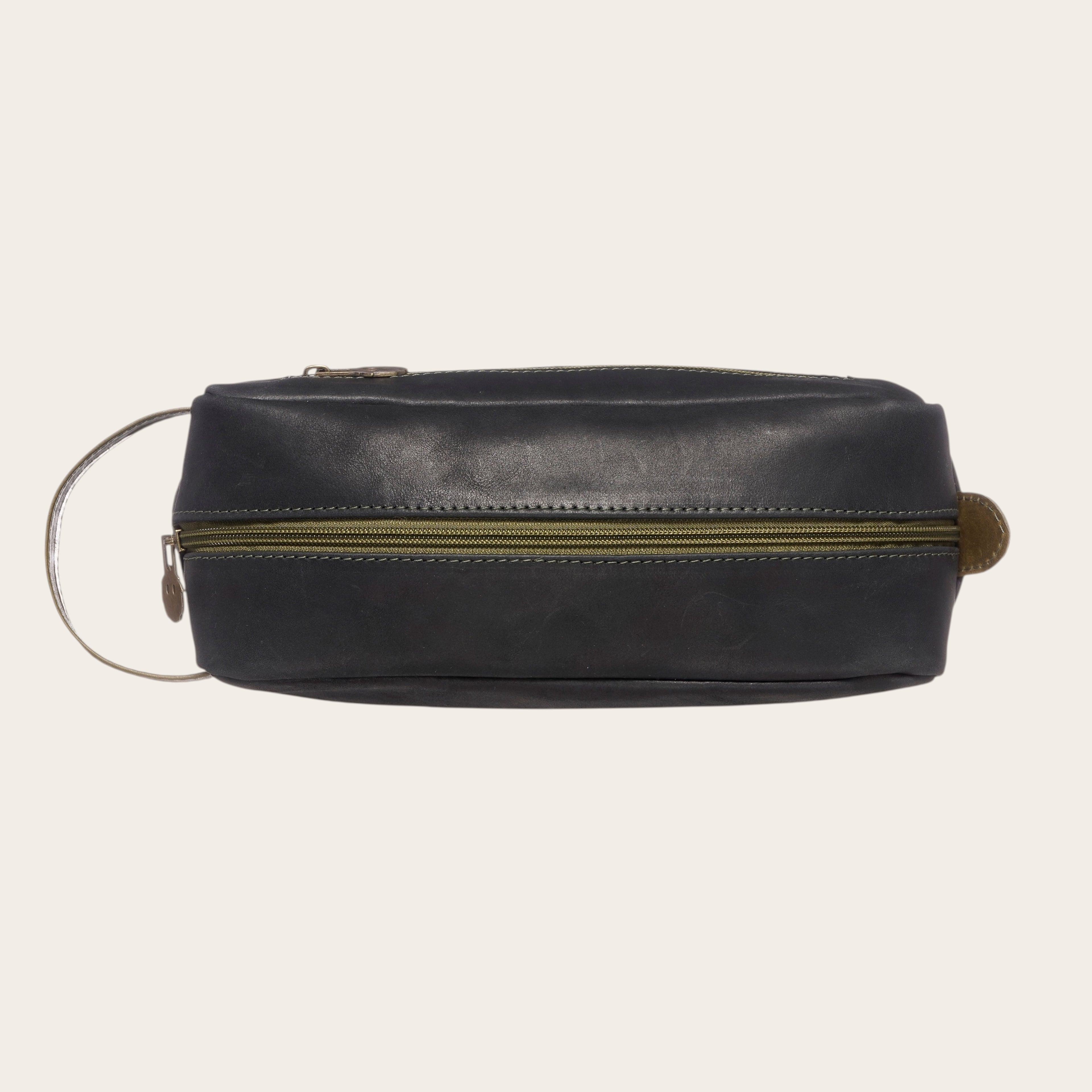 Neceser Loa de cuero negro y verde de OLKI con cremallera verde y asa lateral. Ideal para viaje y aseo.