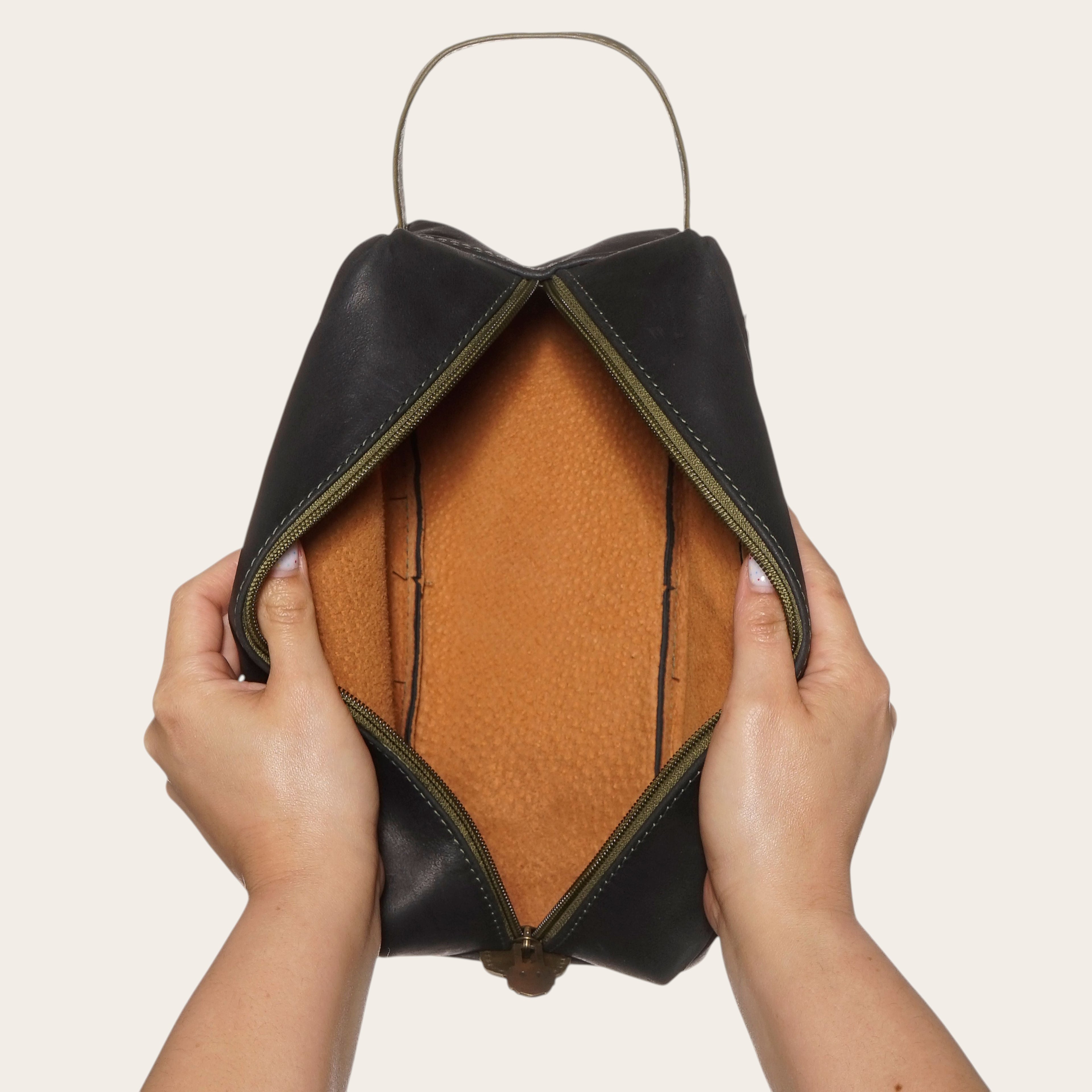 Neceser Loa Negro-Verde de cuero de OLKI con interior naranja. Ideal para viajes y organización.