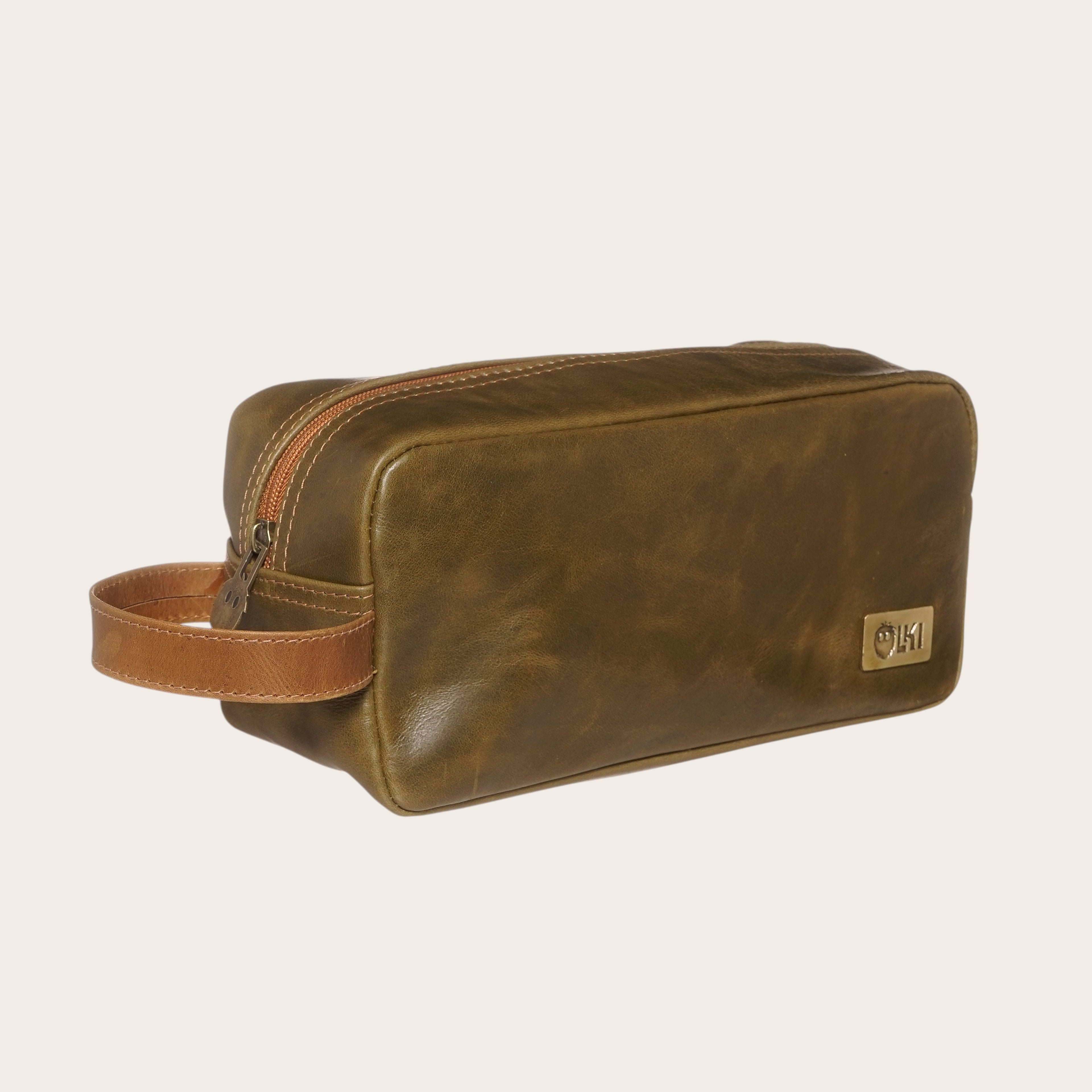 Neceser Loa Verde-Caramel de cuero de OLKI con asa lateral y cierre de cremallera.