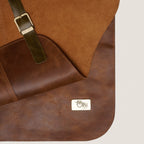 Pechera de cuero natural café OLKI con hebilla metálica y etiqueta de marca, ideal para protección y trabajo manual.