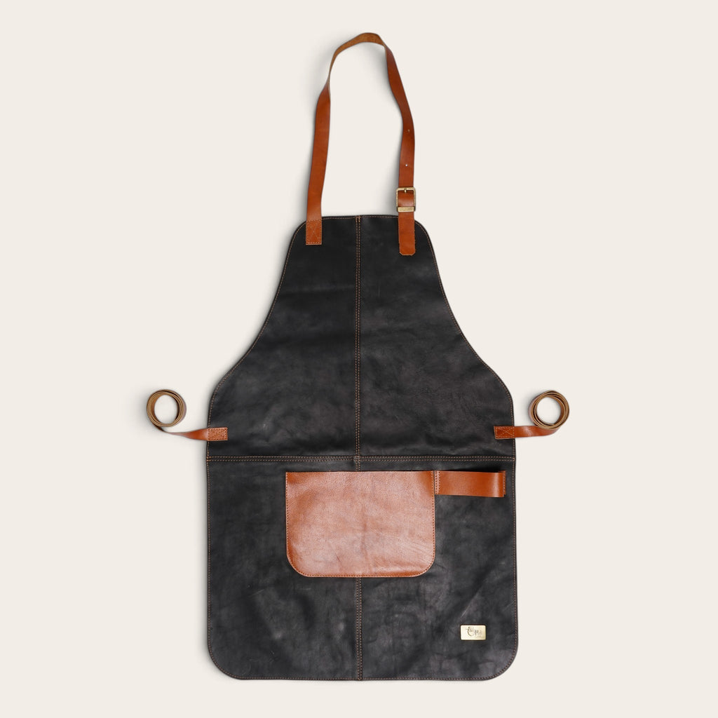 Pechera de cuero natural OLKI color negro con correas y bolsillo en tono café, ideal para protección y trabajo.