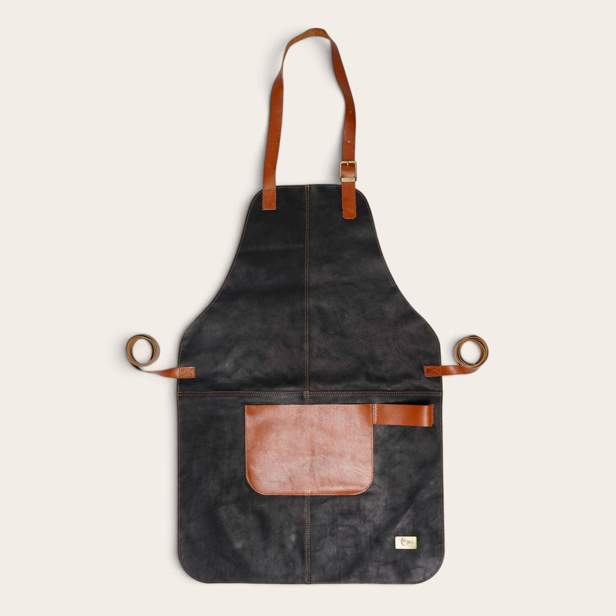 Pechera de cuero natural OLKI color negro con correas y bolsillo en tono café, ideal para protección y trabajo.
