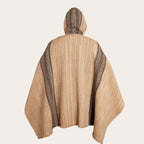 Poncho clásico de lana premium OLKI beige con capucha y rayas laterales oscuras. Tejido artesanal con flecos.