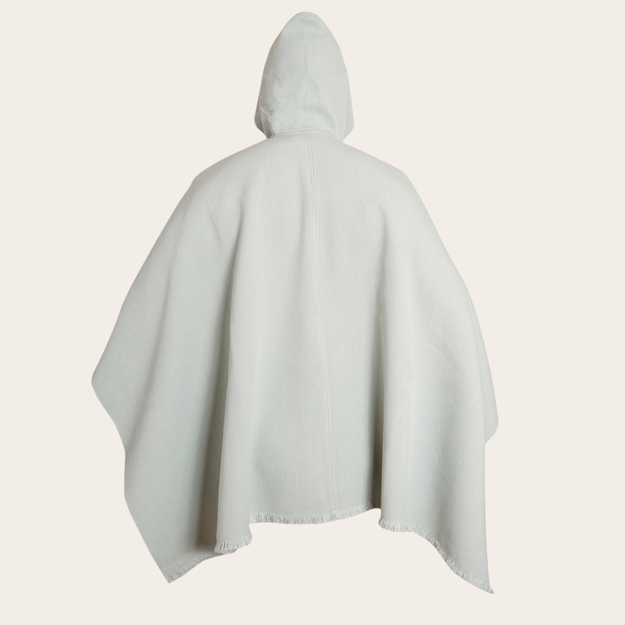 Poncho clásico de lana premium OLKI en color menta con capucha y flecos en el bajo.