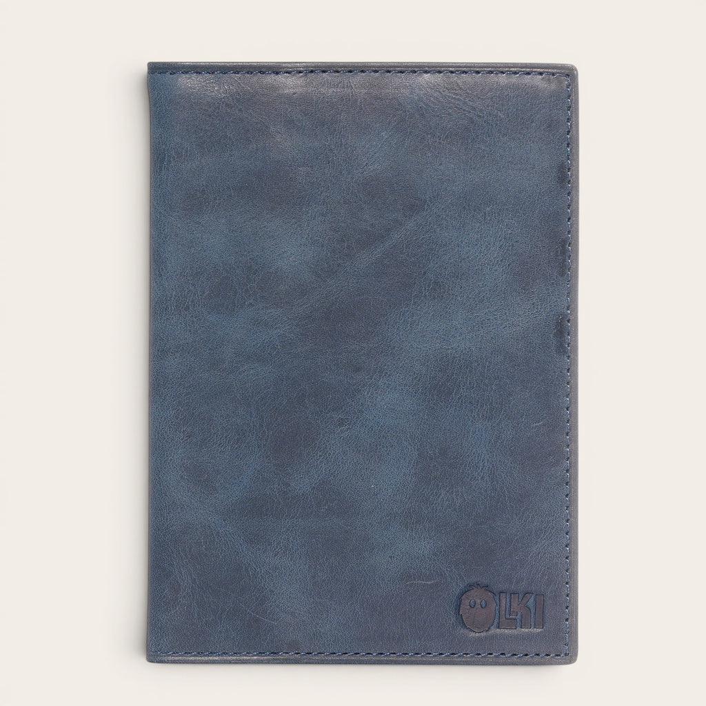 Porta pasaporte OLKI de cuero azul marino con 3 ranuras para tarjetas y separador interno. Dimensiones 10x14 cm.