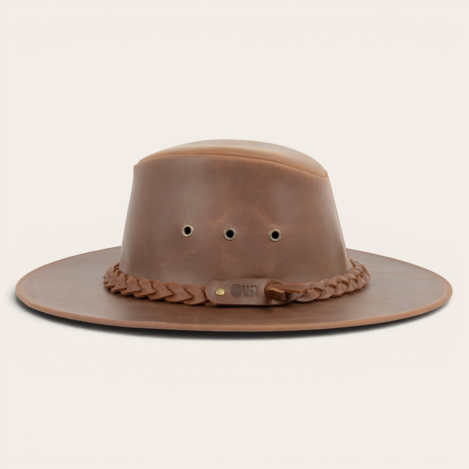 Sombrero marrón de cuero 100% de OLKI con ala ancha, cinta trenzada y remaches metálicos. Estilo rústico y funcional.