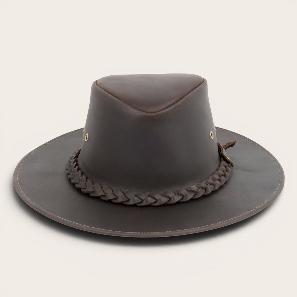 Sombrero de cuero marrón oscuro OLKI con ala ancha, cinta trenzada y remaches metálicos. Estilo rústico y sofisticado.