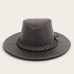 Sombrero de cuero marrón oscuro OLKI con ala ancha, cinta trenzada y remaches metálicos. Estilo rústico y sofisticado.
