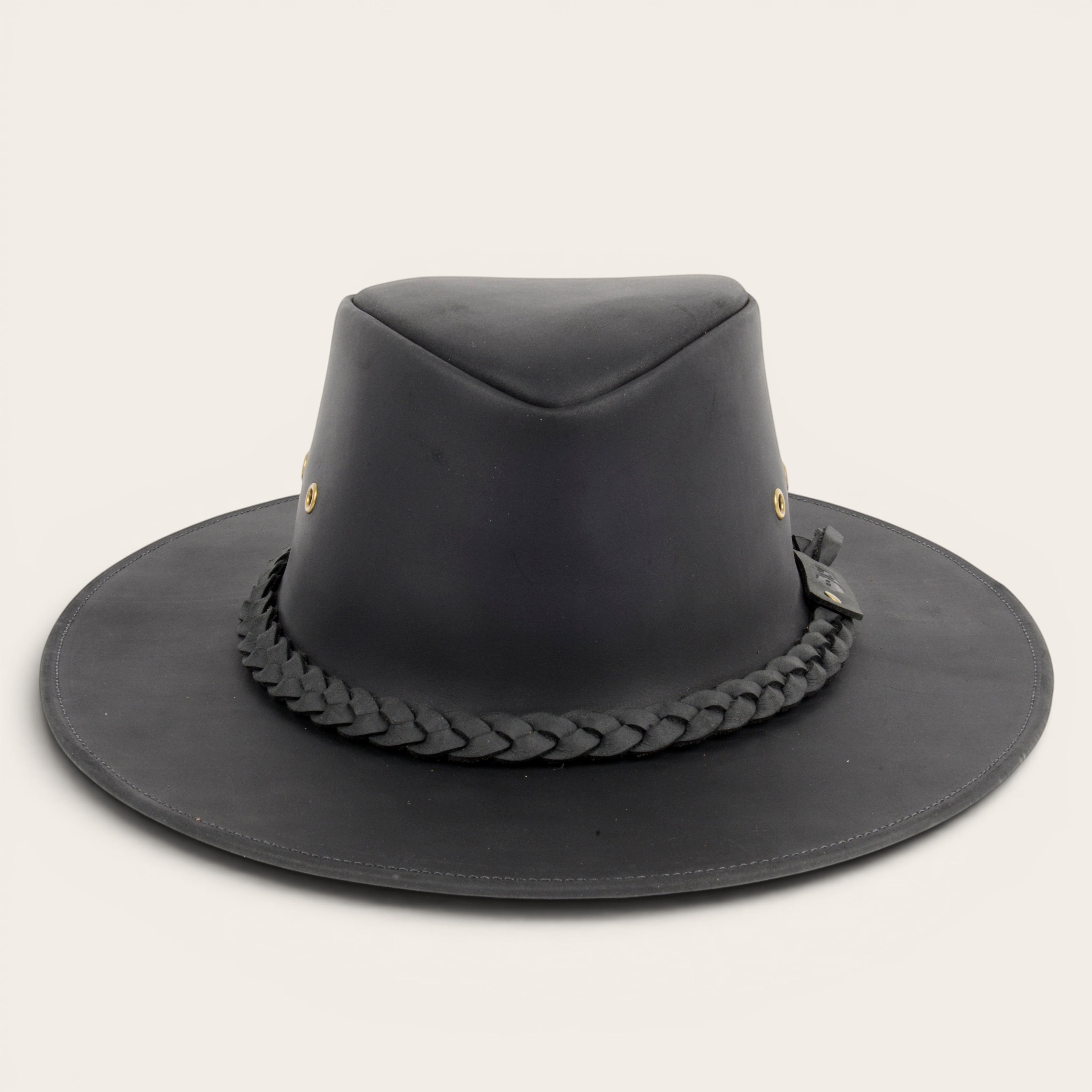 Sombrero negro de cuero 100% OLKI con ala ancha, cinta trenzada y remaches metálicos. Estilo rústico y sofisticado.