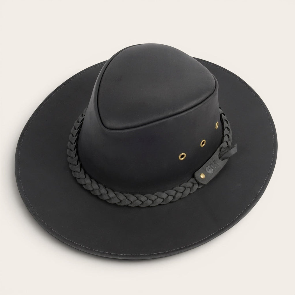 Sombrero negro de cuero OLKI Pumalín con ala ancha, cinta trenzada y remaches metálicos. Estilo rústico y funcional.