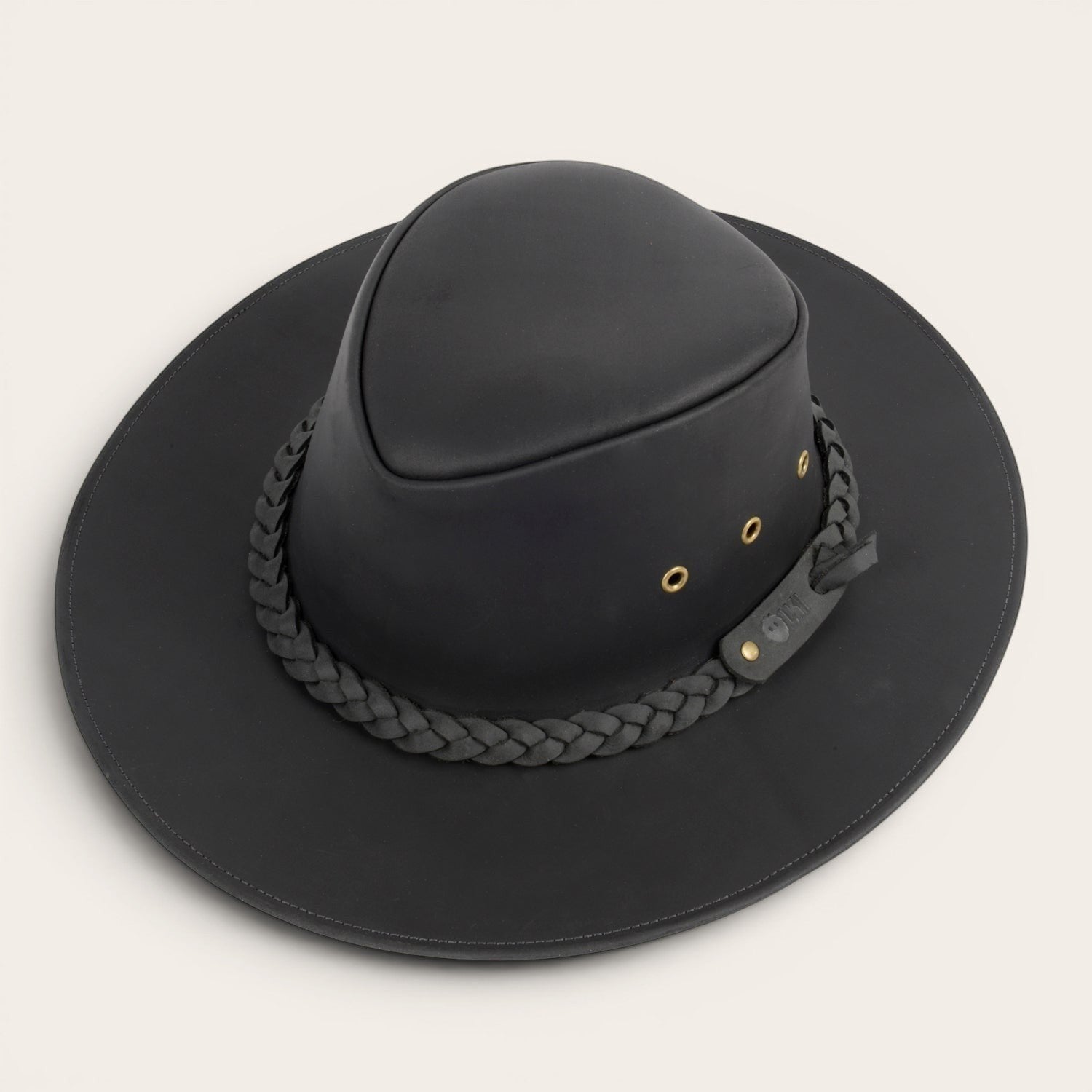 Sombrero negro de cuero OLKI Pumalín con ala ancha, cinta trenzada y remaches metálicos. Estilo rústico y funcional.