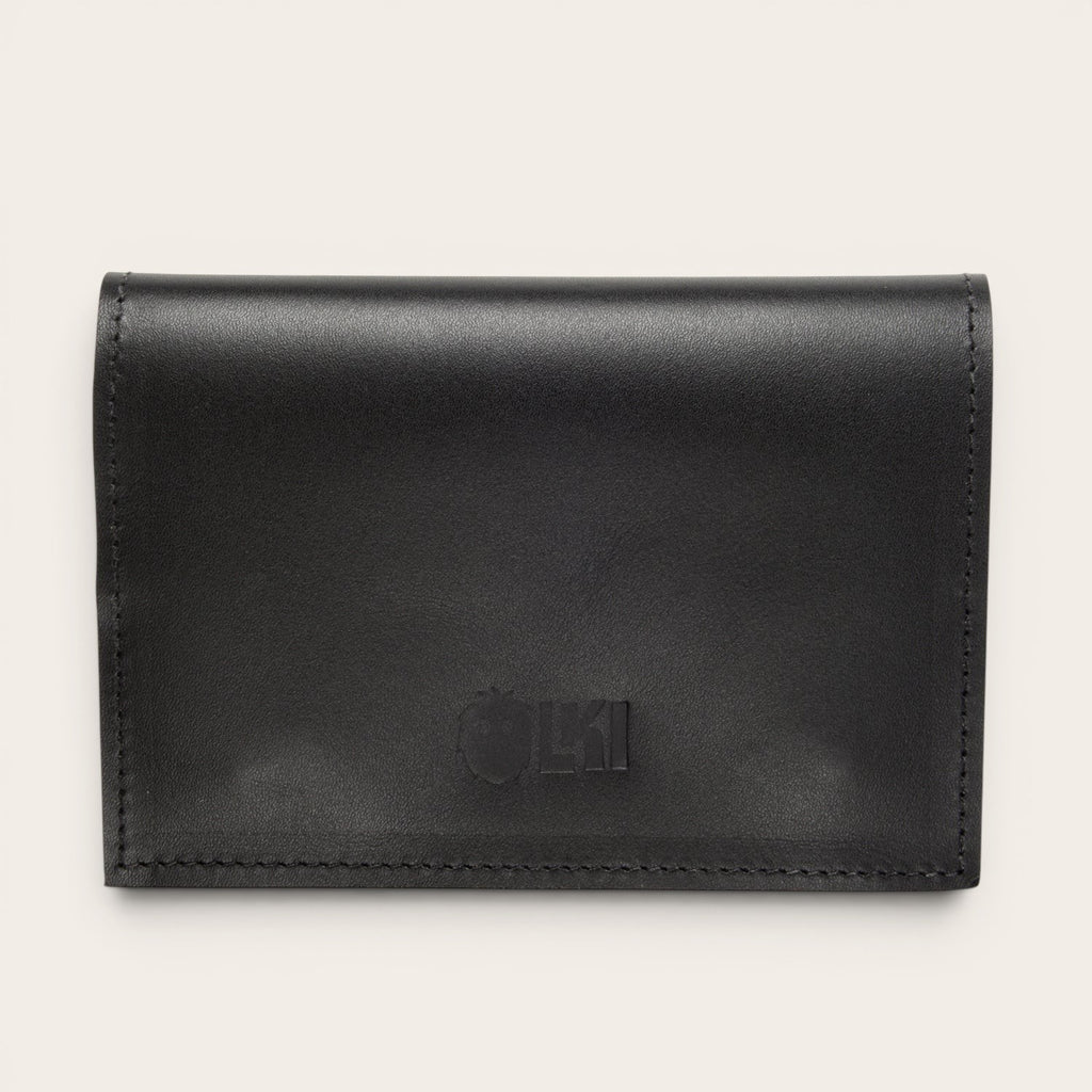 Tabaquera negra de cuero de vacuno de OLKI con broches de imán y compartimentos para filtros, papelillos y encendedor.