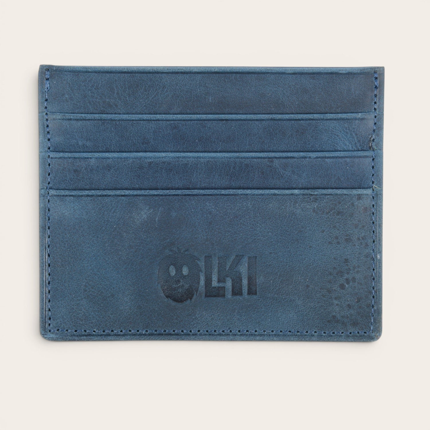Tarjetero minimalista azul marino de piel de OLKI con múltiples ranuras para tarjetas y logo grabado.