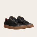 Zapatilla casual de cuero OLKI negra con detalles camel, suela marrón y forro burdeos. Ojales dorados.