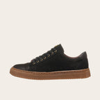 Zapatilla casual de cuero OLKI negra con detalles camel y suela de goma marrón.