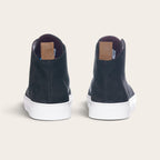 Vista trasera de zapatillas altas OLKI Manquehue en cuero negro con suela blanca y etiqueta de cuero en el talón