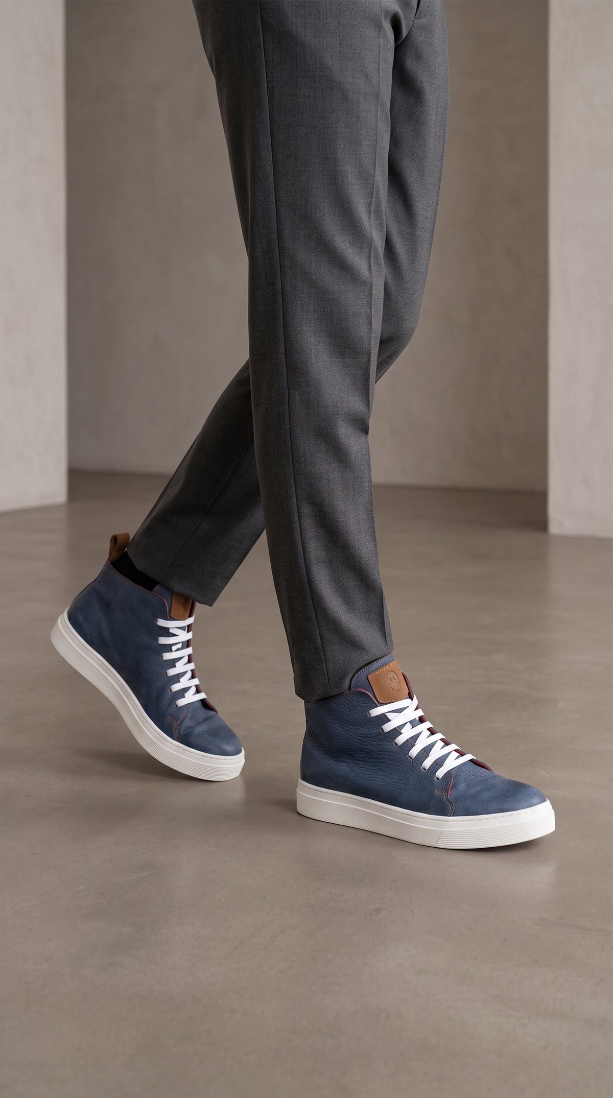Zapatillas altas OLKI Manquehue de cuero azul marino con cordones blancos y suela blanca de perfil grueso.