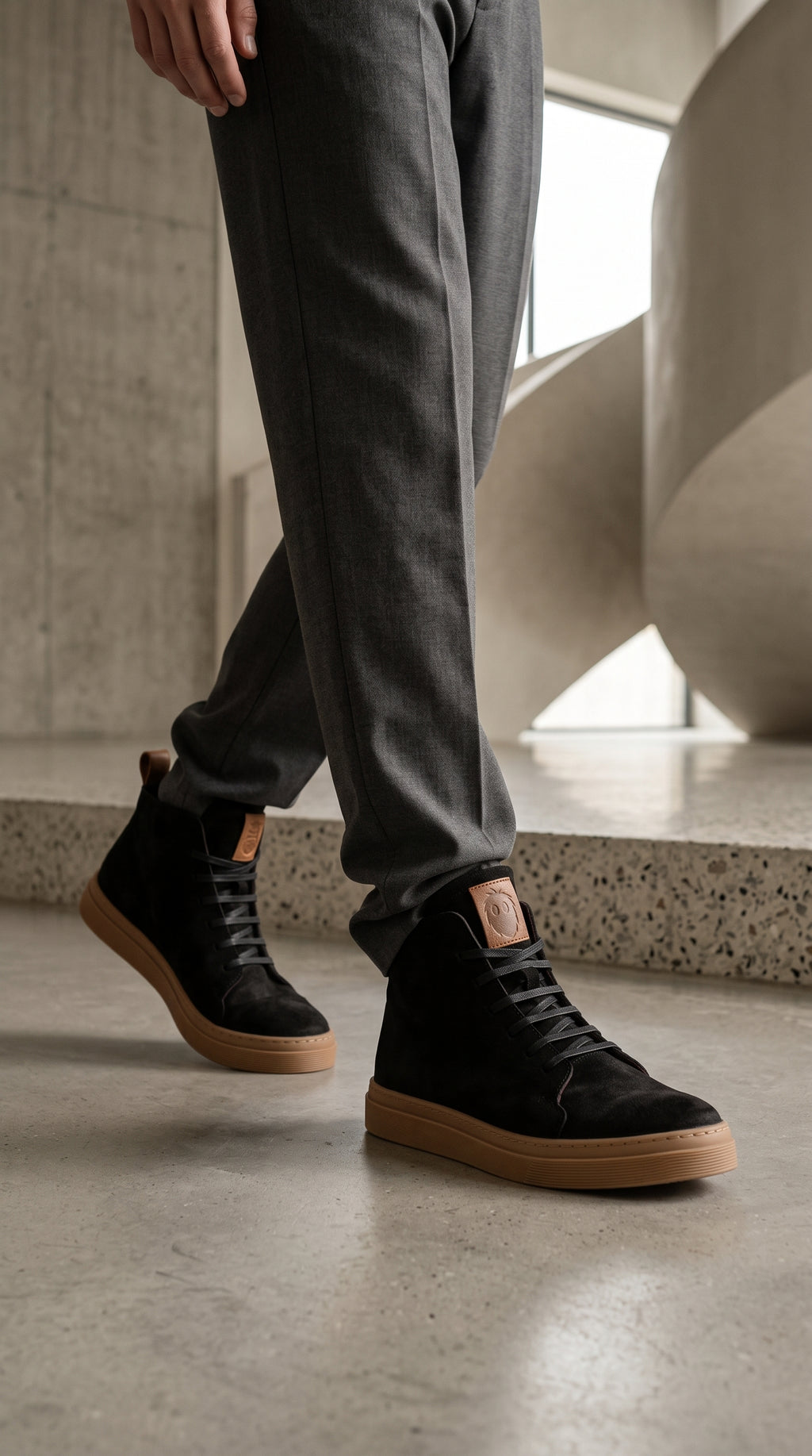 Zapatilla alta negra de Nobuk de OLKI con suela de goma marrón y cordones negros. Diseño urbano.